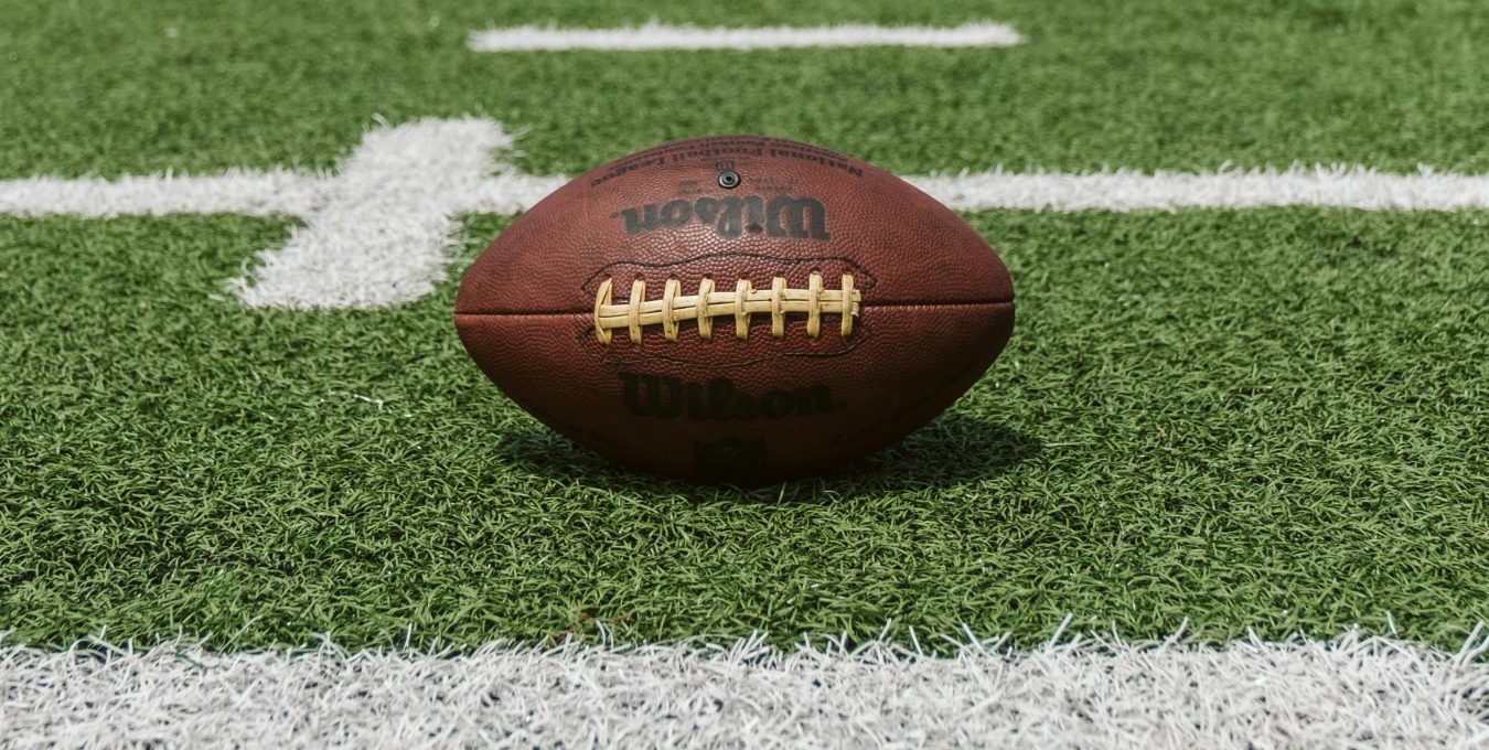 an american football sits on the field at The Preslee